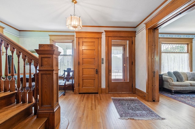 922 Fillmore St, Alexandria, MN 56308 - foyer with light wood-style floors, crown molding, stairway, and a chandelier