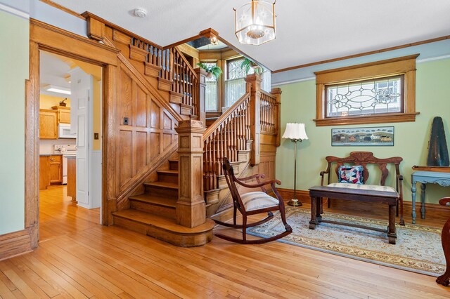 922 Fillmore St, Alexandria, MN 56308 - staircase featuring a chandelier, crown molding, and wood-type flooring