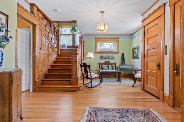 922 Fillmore St, Alexandria, MN 56308 - entrance foyer with light wood-style flooring, stairway, and ornamental molding