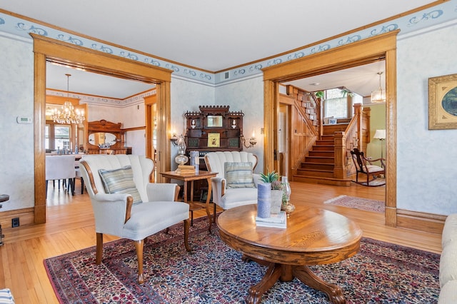 922 Fillmore St, Alexandria, MN 56308 - living area with a chandelier, hardwood / wood-style flooring, ornamental molding, stairway, and wallpapered walls