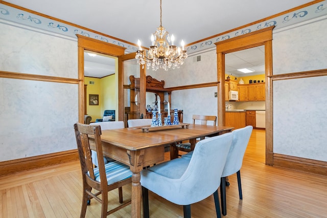 922 Fillmore St, Alexandria, MN 56308 - dining space featuring a chandelier, light wood-type flooring, and crown molding