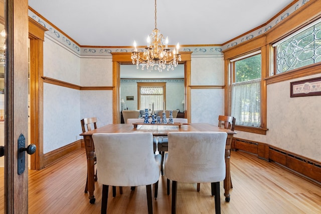 922 Fillmore St, Alexandria, MN 56308 - dining room featuring light wood finished floors, a chandelier, ornamental molding, and wallpapered walls