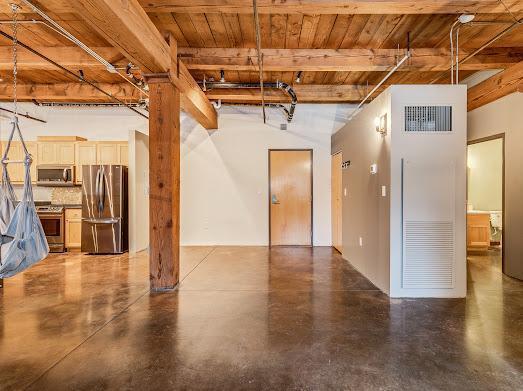127 5th St NE Unit G08, Minneapolis, MN 55413 - unfurnished living room with wood ceiling with exposed beams and concrete floors