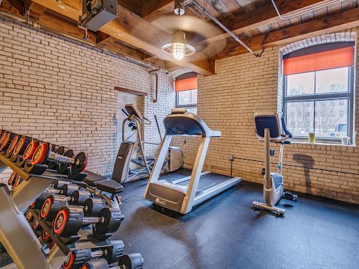 127 5th St NE Unit G08, Minneapolis, MN 55413 - exercise room with brick wall, wood ceiling, and ceiling fan