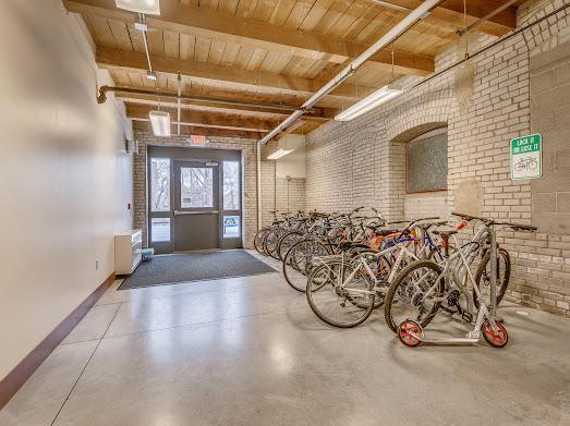 127 5th St NE Unit G08, Minneapolis, MN 55413 - entryway with wood ceiling with exposed beams, brick wall, baseboards, and finished concrete flooring
