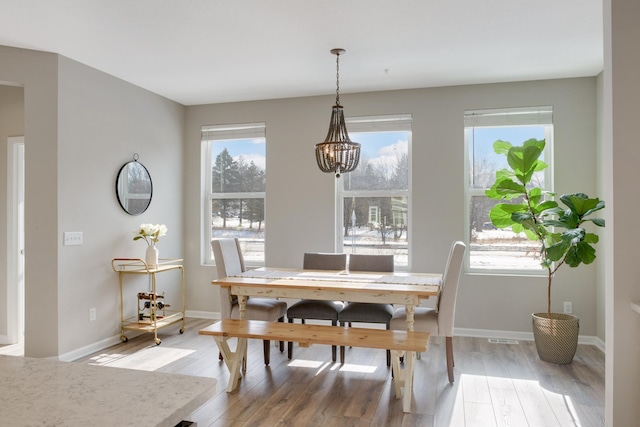 645 Satori Way, Chaska, MN 55318 - dining room featuring light wood-style floors, a chandelier, healthy amount of natural light, and baseboards