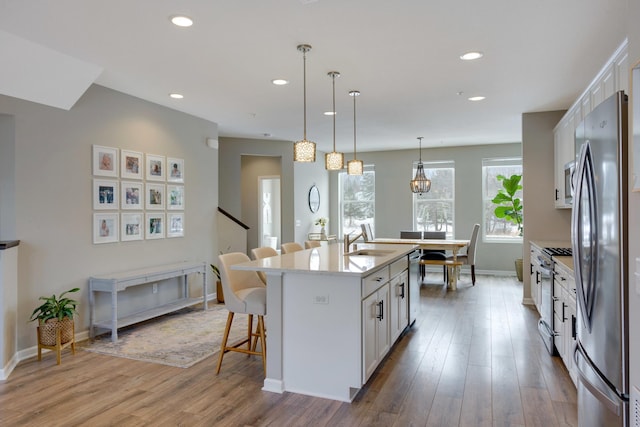 645 Satori Way, Chaska, MN 55318 - kitchen featuring appliances with stainless steel finishes, a breakfast bar area, white cabinets, a sink, and recessed lighting