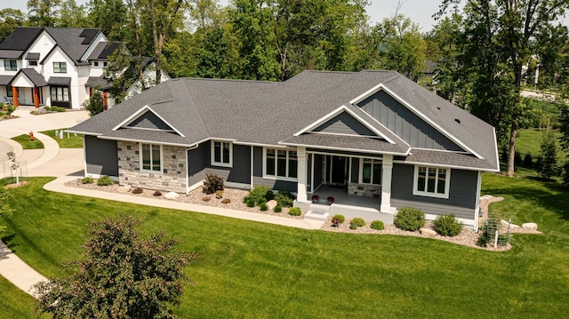 3039 Lady Slipper Ln SW, Rochester, MN 55902 - rear view of house with board and batten siding, stone siding, a yard, and covered porch
