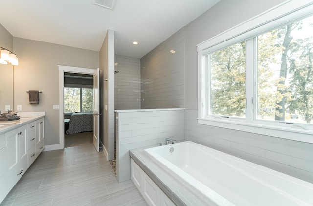 3039 Lady Slipper Ln SW, Rochester, MN 55902 - bathroom featuring vanity, a bath, a tile shower, and recessed lighting