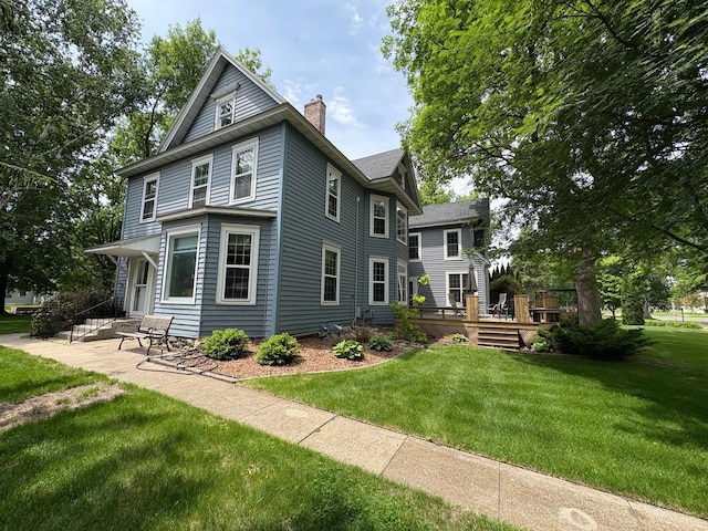 1710 Maple Ave, Benson, MN 56215 - back of property with a chimney, a lawn, and a deck