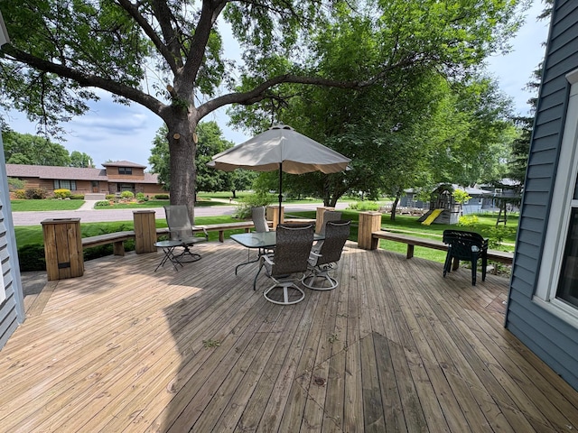 1710 Maple Ave, Benson, MN 56215 - wooden deck featuring outdoor dining area, a playground, and a yard