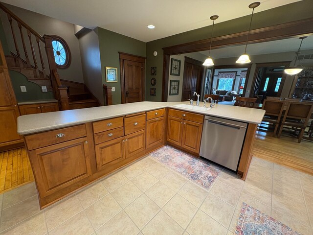 1710 Maple Ave, Benson, MN 56215 - kitchen with stainless steel dishwasher, a sink, light countertops, light tile patterned floors, and brown cabinets
