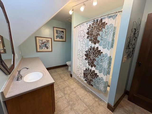 1710 Maple Ave, Benson, MN 56215 - bathroom featuring vanity, toilet, lofted ceiling, baseboards, and shower / bath combo with shower curtain