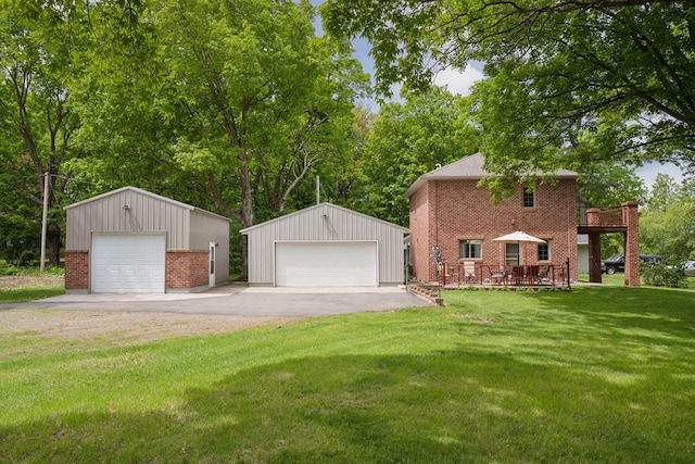 501 Lakeshore Blvd W, Onamia, MN 56359 - view of front of home with a detached garage, brick siding, an outbuilding, a front yard, and view of wooded area
