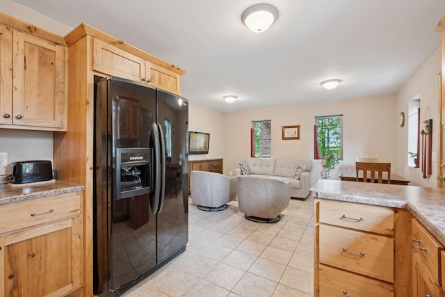 501 Lakeshore Blvd W, Onamia, MN 56359 - kitchen with black refrigerator with ice dispenser, light tile patterned floors, open floor plan, light countertops, and light brown cabinets
