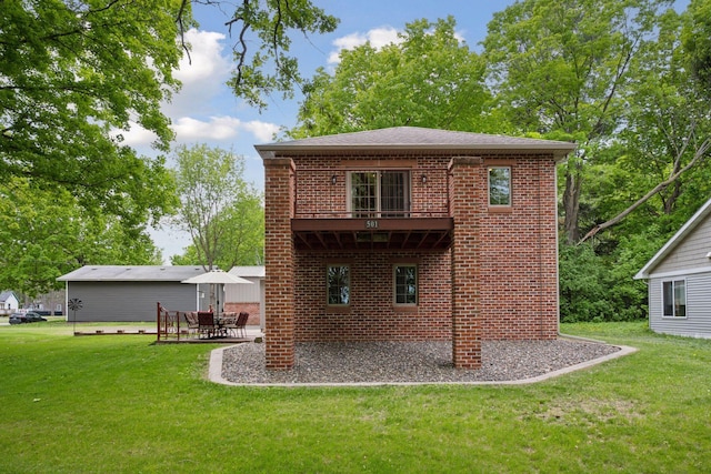 501 Lakeshore Blvd W, Onamia, MN 56359 - rear view of house featuring a balcony, brick siding, a lawn, a patio, and roof with shingles