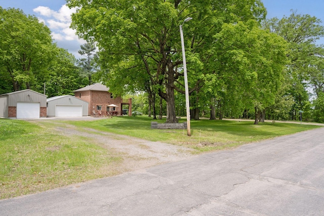 501 Lakeshore Blvd W, Onamia, MN 56359 - view of front of property with a detached garage, brick siding, a front yard, an outdoor structure, and view of scattered trees
