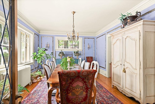 2401 5th St, Duluth, MN 55812 - dining area featuring radiator heating unit, a chandelier, light wood-style flooring, and ornamental molding