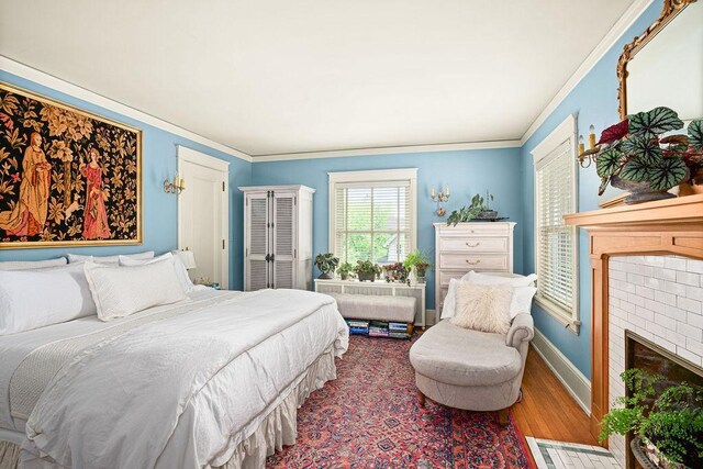 2401 5th St, Duluth, MN 55812 - bedroom featuring wood finished floors, ornamental molding, baseboards, and a fireplace
