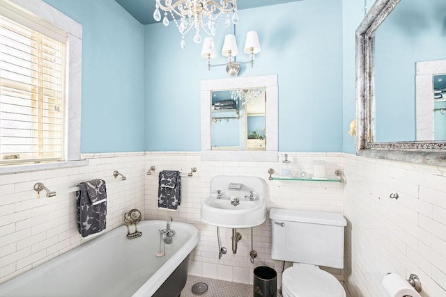 2401 5th St, Duluth, MN 55812 - full bath with a bath, toilet, wainscoting, tile walls, and a chandelier