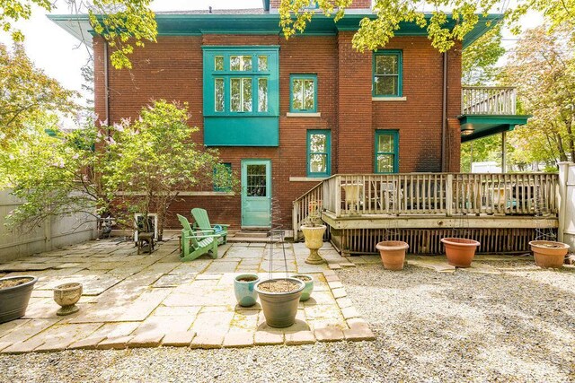 2401 5th St, Duluth, MN 55812 - rear view of property featuring brick siding, a patio area, and a wooden deck