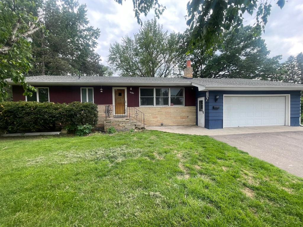 1121 Ramsey St W, Stillwater, MN 55082 - ranch-style home with an attached garage, asphalt driveway, a chimney, and a front yard