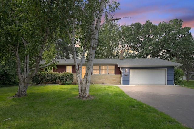 1121 Ramsey St W, Stillwater, MN 55082 - view of front of house featuring asphalt driveway, a front lawn, a garage, and a chimney