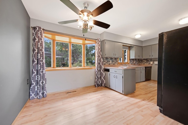 1121 Ramsey St W, Stillwater, MN 55082 - kitchen featuring gray cabinetry, ceiling fan, light wood-style flooring, decorative backsplash, and a peninsula