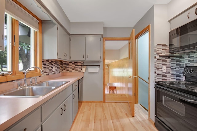 1121 Ramsey St W, Stillwater, MN 55082 - kitchen featuring black appliances, light countertops, light wood-style floors, and decorative backsplash