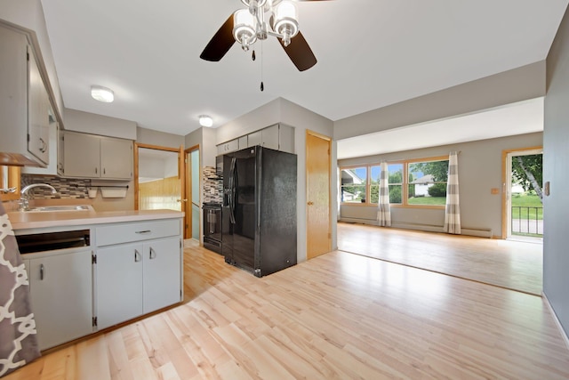 1121 Ramsey St W, Stillwater, MN 55082 - kitchen with black refrigerator with ice dispenser, ceiling fan, backsplash, and light wood-type flooring
