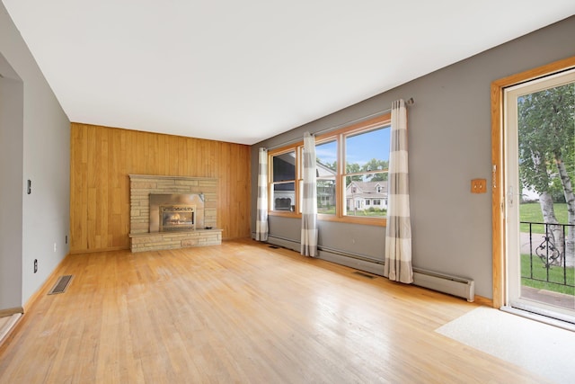 1121 Ramsey St W, Stillwater, MN 55082 - unfurnished living room featuring wood finished floors, plenty of natural light, wood walls, and a stone fireplace
