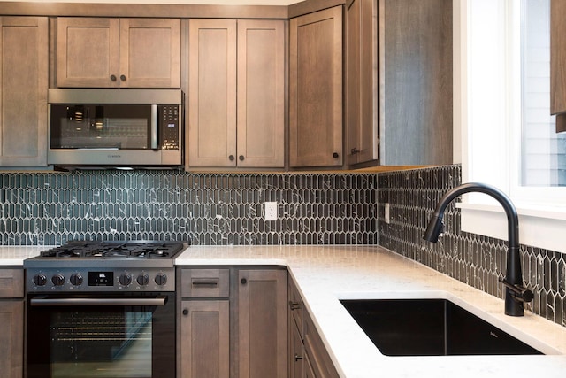 1213 54th St, Saint Joseph Twp, WI 54016 - kitchen featuring stainless steel appliances, a sink, backsplash, and light stone countertops