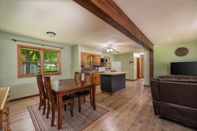 615 Eisenhower Dr, Saint Croix Falls, WI 54024 - dining room featuring light wood finished floors, baseboards, a ceiling fan, and a textured ceiling