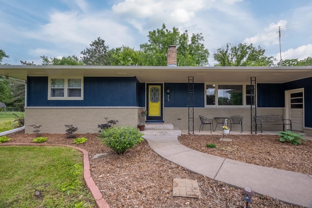 615 Eisenhower Dr, Saint Croix Falls, WI 54024 - ranch-style house with a chimney, brick siding, and a porch