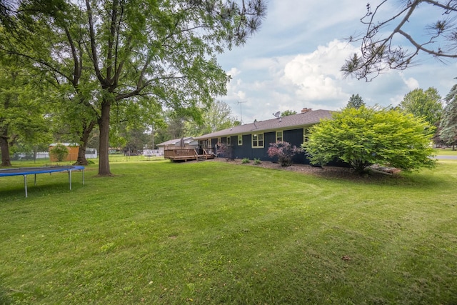 615 Eisenhower Dr, Saint Croix Falls, WI 54024 - view of green lawn with a wooden deck and a trampoline
