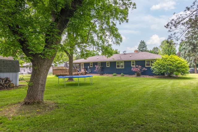 615 Eisenhower Dr, Saint Croix Falls, WI 54024 - back of property featuring a trampoline, a yard, and a chimney