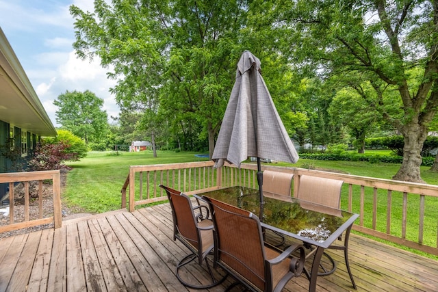615 Eisenhower Dr, Saint Croix Falls, WI 54024 - wooden terrace featuring outdoor dining space, a lawn, and view of scattered trees