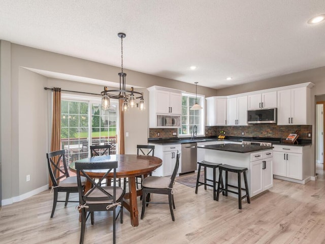 15000 Bridgewater Dr, Savage, MN 55378 - dining space featuring plenty of natural light, light wood-style floors, a chandelier, a textured ceiling, and recessed lighting