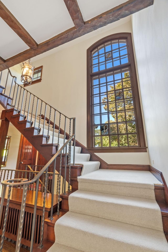 4601 Lake Harriet Pkwy, Minneapolis, MN 55419 - staircase featuring a chandelier, coffered ceiling, beam ceiling, and baseboards