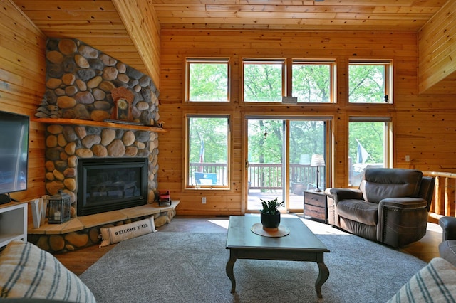 1147 Hillside Ln, Edgewater, WI 54817 - living area featuring healthy amount of natural light, wood walls, a stone fireplace, high vaulted ceiling, and wood ceiling