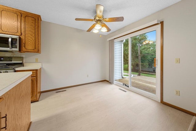 5214 148th St W, Apple Valley, MN 55124 - kitchen featuring electric stove, stainless steel microwave, light countertops, ceiling fan, and brown cabinets