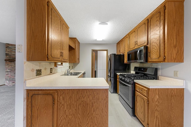5214 148th St W, Apple Valley, MN 55124 - kitchen with appliances with stainless steel finishes, a textured ceiling, a peninsula, light countertops, and brown cabinets