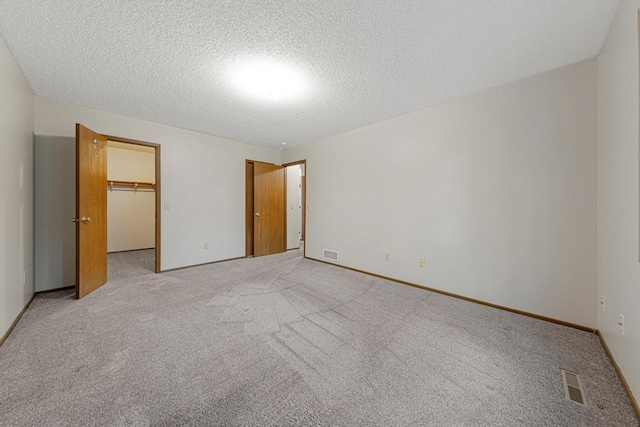5214 148th St W, Apple Valley, MN 55124 - unfurnished bedroom featuring light carpet, a textured ceiling, a spacious closet, and a closet