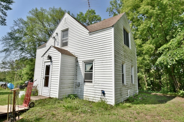 67433 325th St, Watkins, MN 55389 - view of side of property with a shingled roof and a yard
