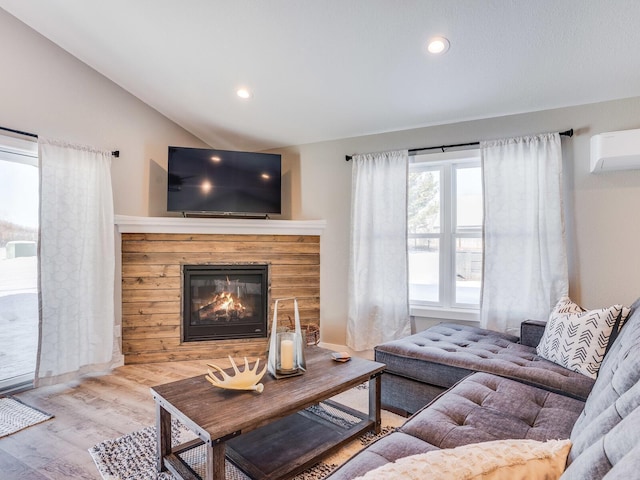2855 28 11/16 St, Cedar Lake Twp, WI 54817 - living area featuring an AC wall unit, lofted ceiling, a glass covered fireplace, wood finished floors, and recessed lighting
