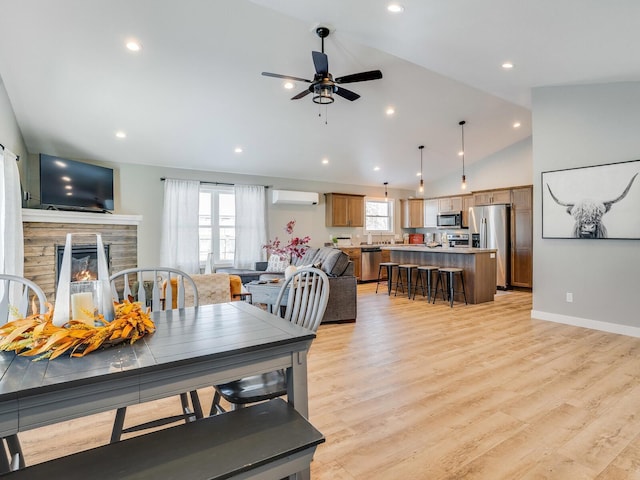 2855 28 11/16 St, Cedar Lake Twp, WI 54817 - dining room with a wall unit AC, lofted ceiling, a ceiling fan, light wood finished floors, and a fireplace