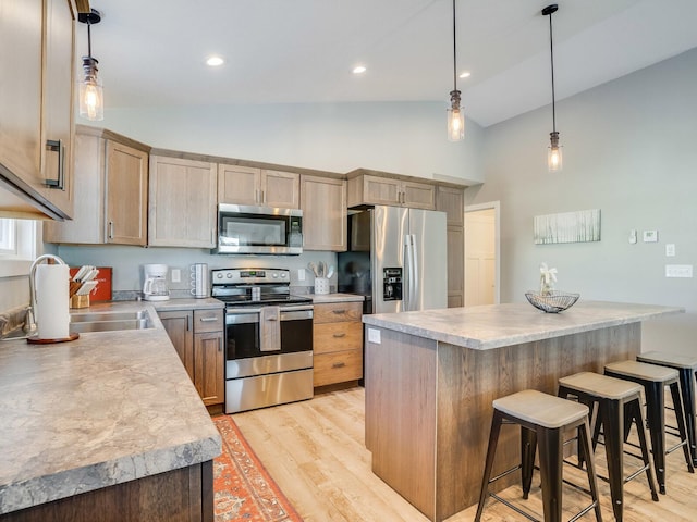 2855 28 11/16 St, Cedar Lake Twp, WI 54817 - kitchen with stainless steel appliances, high vaulted ceiling, light wood-type flooring, a sink, and a kitchen bar