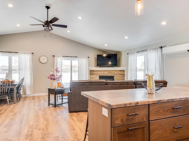 2855 28 11/16 St, Cedar Lake Twp, WI 54817 - kitchen with a ceiling fan, a stone fireplace, recessed lighting, light wood-style flooring, and a breakfast bar