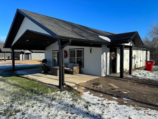 2855 28 11/16 St, Cedar Lake Twp, WI 54817 - snow covered rear of property with outdoor lounge area, a patio area, and roof with shingles