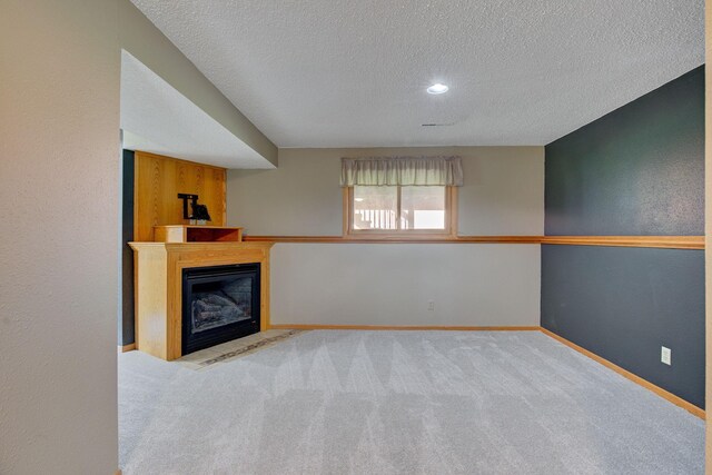 407 4th Ave NE, Kasson, MN 55944 - unfurnished living room with a textured ceiling, carpet floors, and a fireplace